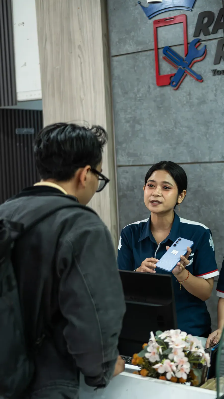 Pelanggan dilayani di meja depan Raja Repair
