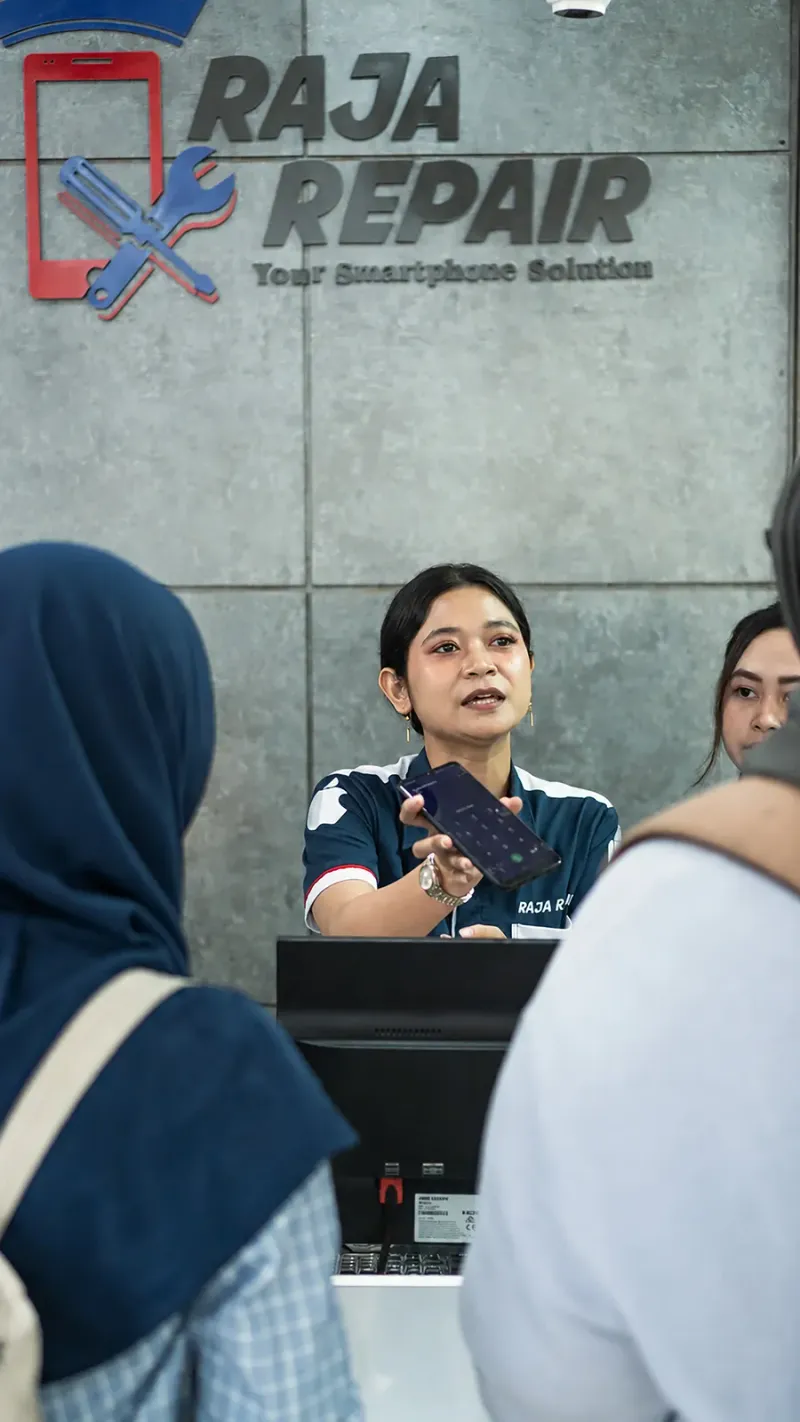 Staf Raja Repair melayani pelanggan di meja depan