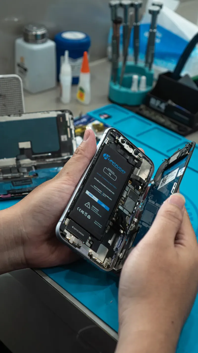 Teknisi memperbaiki smartphone di meja kerja